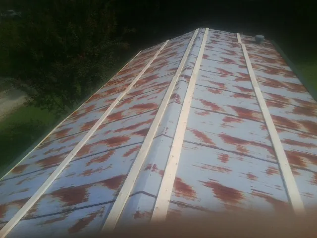 Rusted metal roof panels with new wood purlins before replacement — Storm Damage Roof Repair in Selbyville by Roofing Brothers