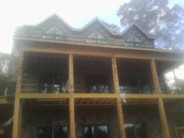 Dormers and porch framing on a large log home under construction — Roof Coating work by our crew in Selbyville